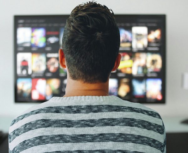 uomo guarda uno spot televisivo